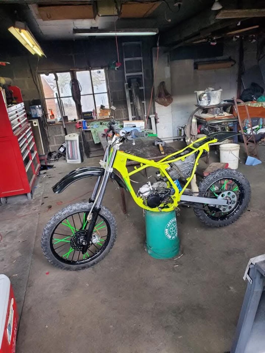 A motorcycle with a bright yellow frame during assembly.