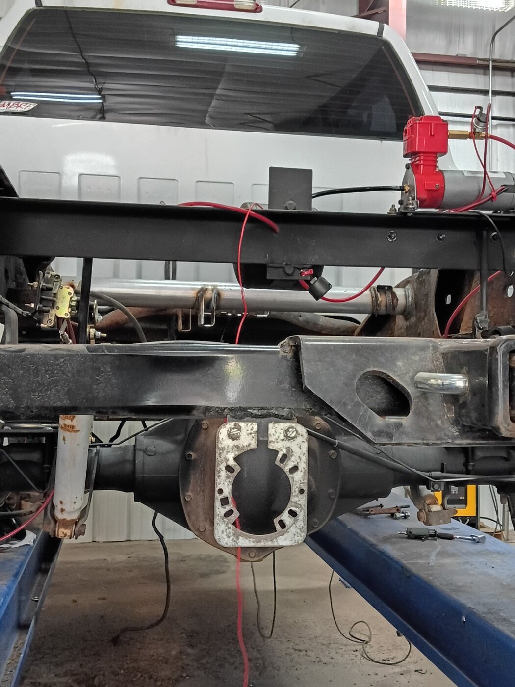 A rear axle and open differential housing photographed in the workshop.