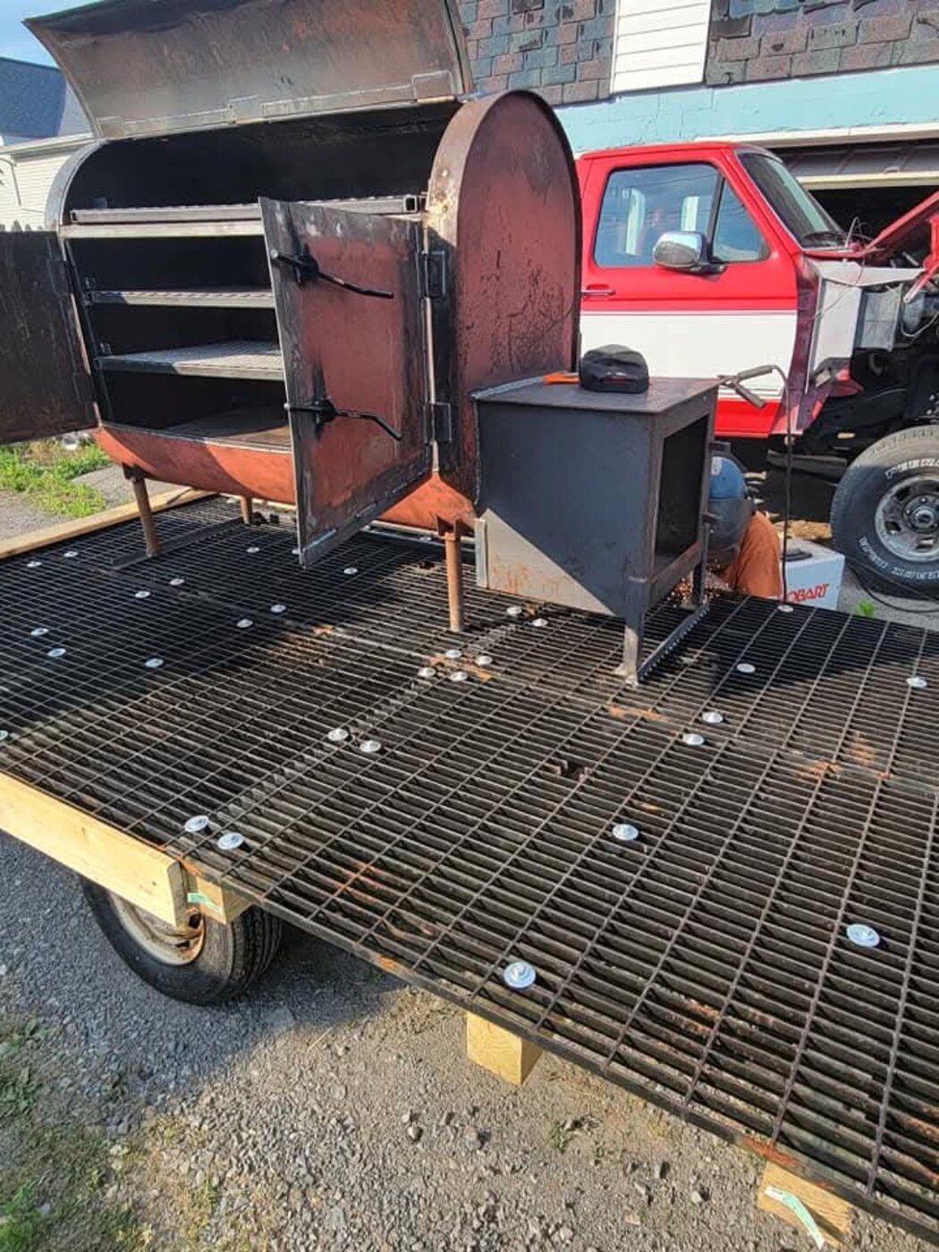 A large steel smoker assembly on a flatbed trailer.