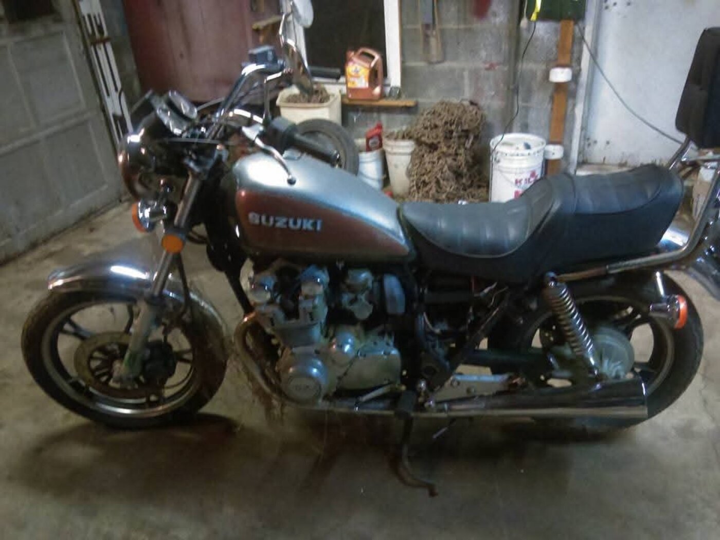 A Suzuki motorcycle photographed inside a garage.